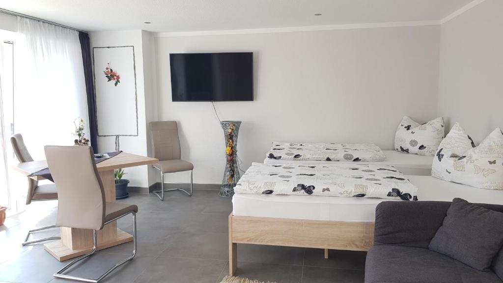a white bedroom with a bed and a couch at Zimmervermietung Kolkwitz - Pension Geisler in Kolkwitz