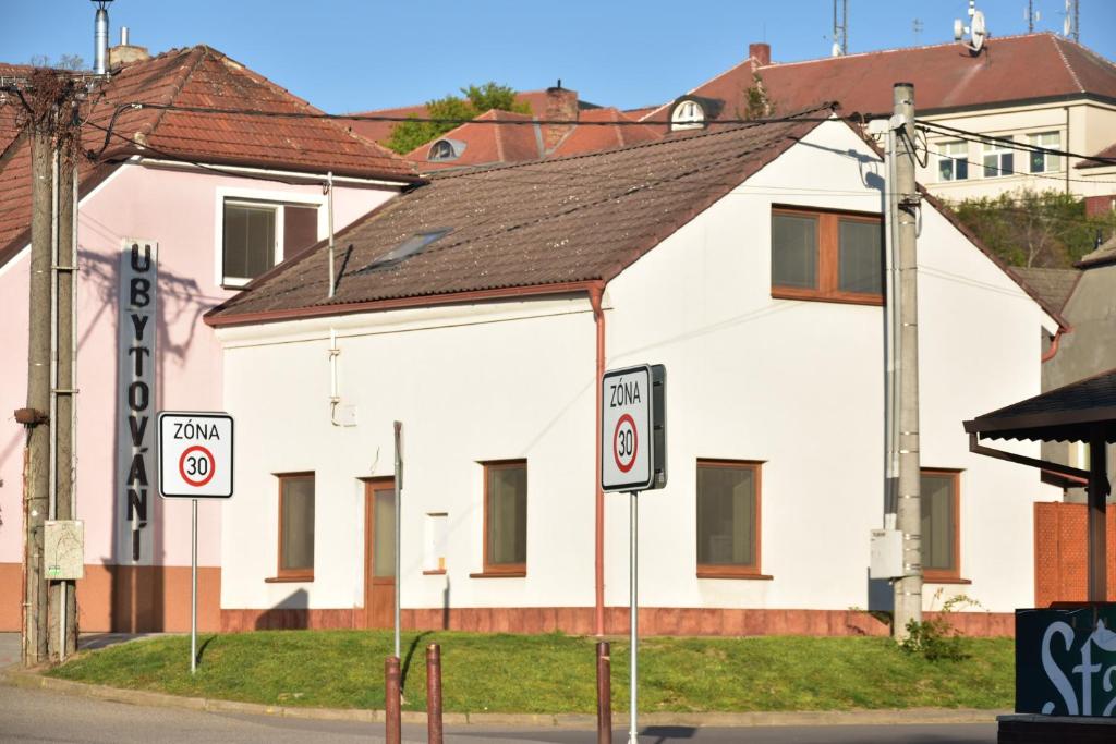 un edificio blanco con letreros de la calle delante de él en Apartmán-Hovorany en Hovorany