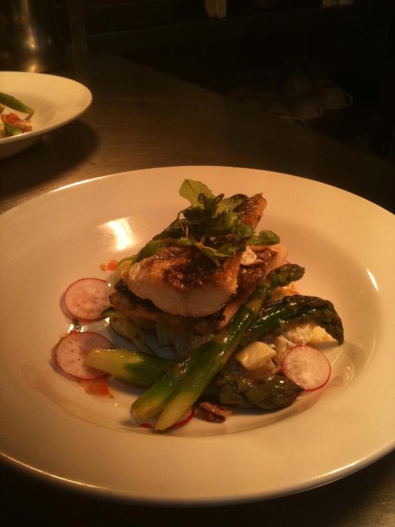 a plate of food with meat and vegetables on a table at Sutherland House in Southwold