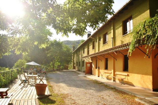 a building with benches and a table in front of it at Alberg Can Ribals in Lles