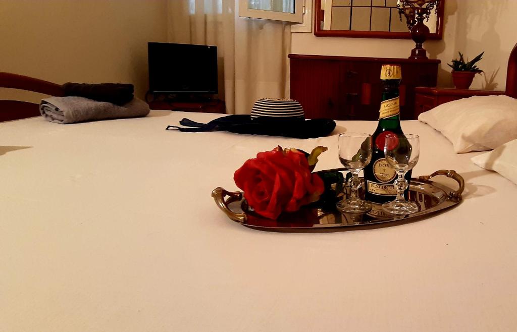 a tray with a bottle of wine and roses on a bed at Tsina’s apartments in Ágios Nikólaos