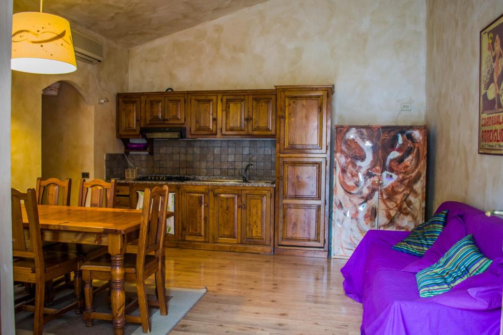 een keuken met houten kasten en een tafel met een eetkamer bij Le casette sul lago in Ronciglione
