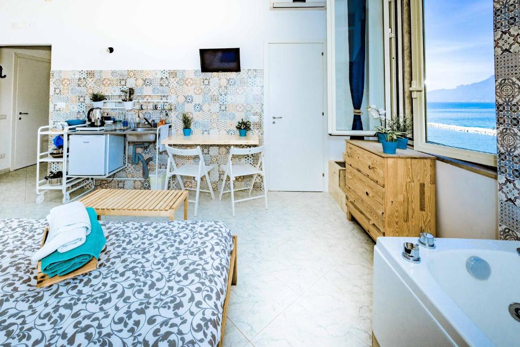 łazienka z wanną i kuchnia z widokiem na ocean w obiekcie On the beach Sea-view&Kitchen In Room w mieście Salerno