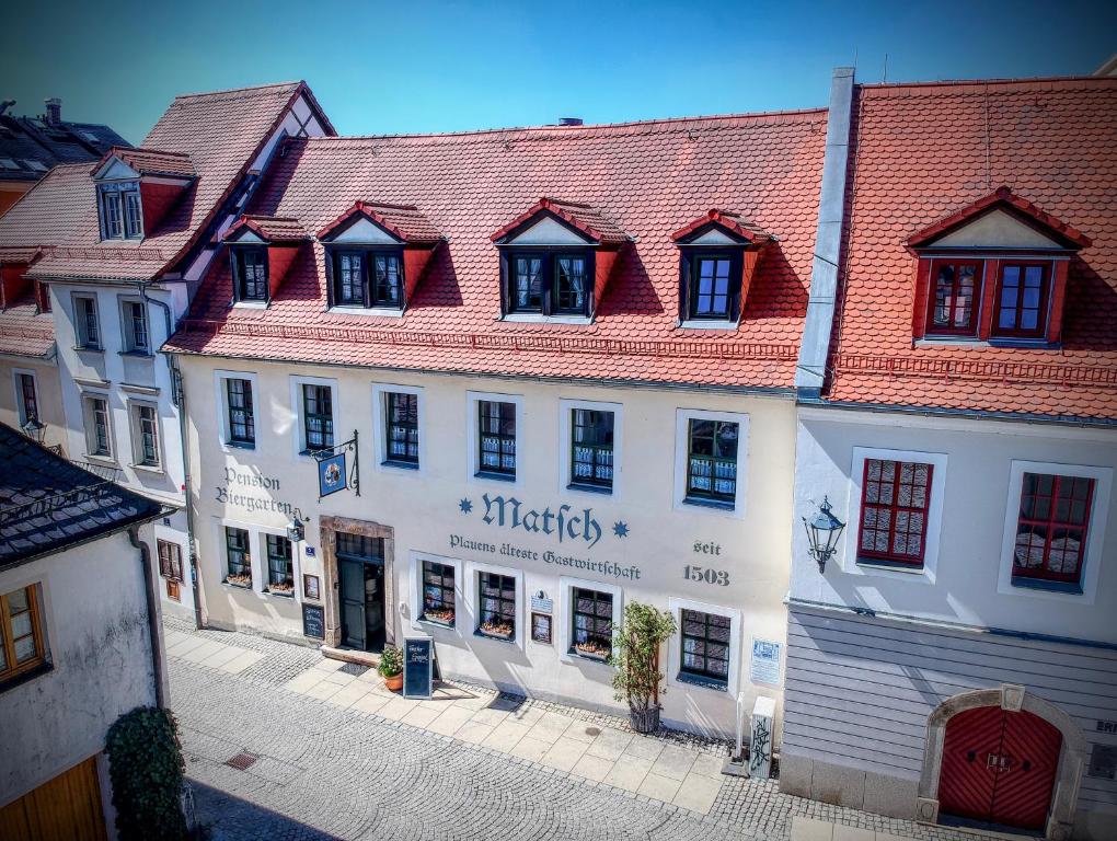 un grand bâtiment blanc avec un toit rouge dans l'établissement Matsch - Plauens älteste Gastwirtschaft, à Plauen