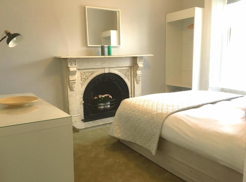 a bedroom with a fireplace with a bed and a television at Donnybrook Townhouse in Dublin