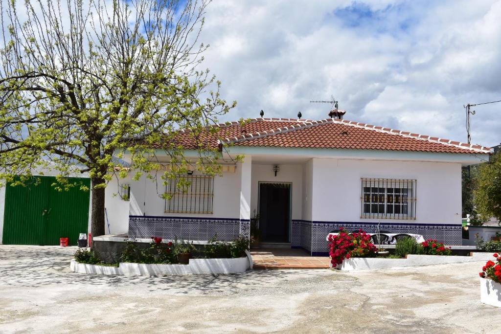 uma casa branca com um telhado vermelho em CASA RURAL ALEJO em Málaga