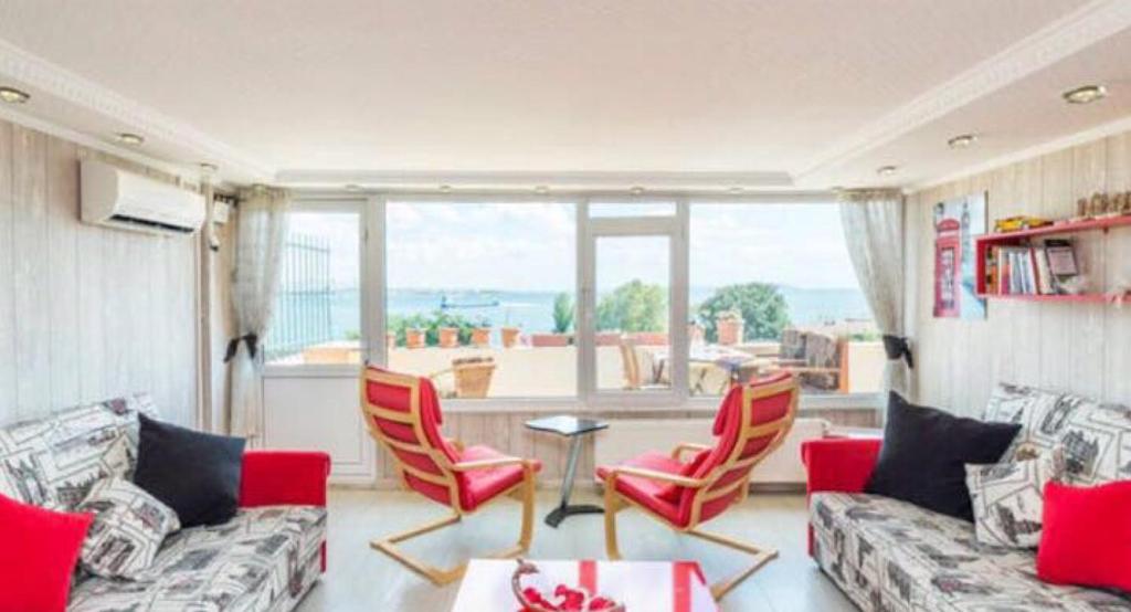 伊斯坦堡的住宿－Front of Sea View Apartments Sultanahmet SEA VIEW，带沙发和椅子的客厅以及大窗户。
