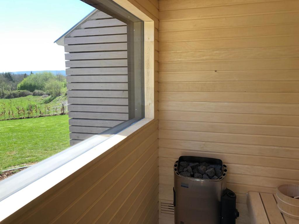 a window on the side of a house with a trash can at Vue d'en Haut in Durbuy