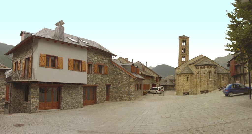 an old stone building with a clock tower on a street at Casa Valenti exterior in Taüll