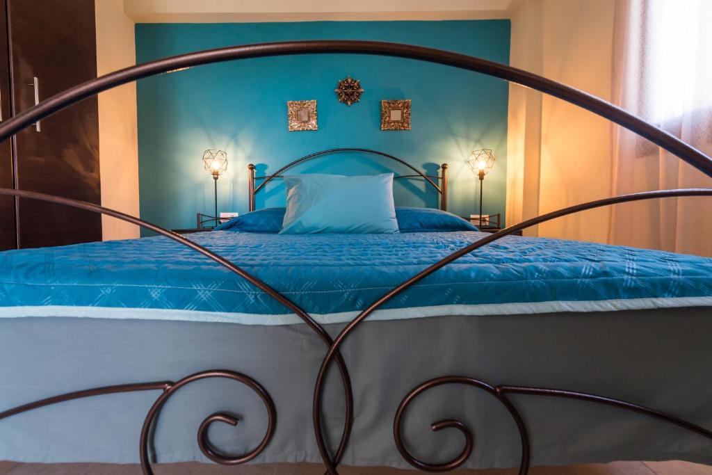 a blue bedroom with a bed with a metal frame at Roxani's Apartments in Ayios Nikolaos Sithonia
