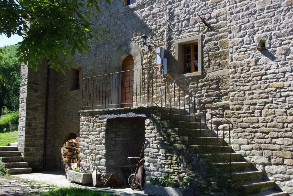 een stenen gebouw met een trap en een balkon bij Vinco in Castel del Rio