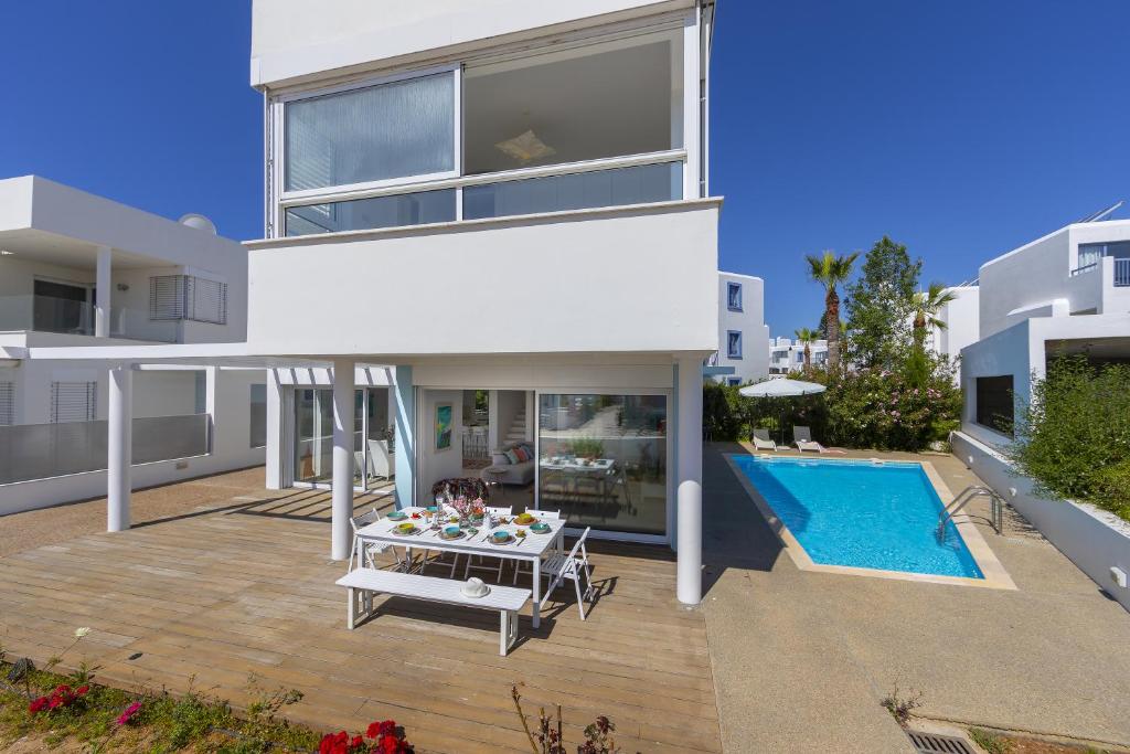 a house with a patio and a swimming pool at Oceania Villa in Protaras