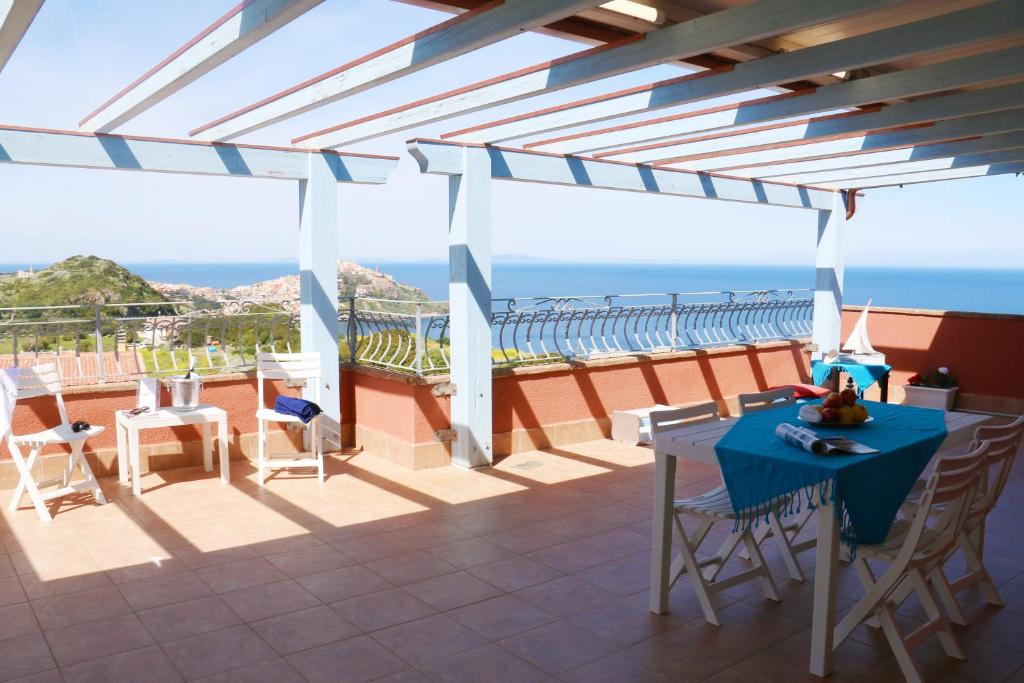 a patio with a table and chairs and the ocean at SARDINIA RE - Attico Baja Ostina in Castelsardo