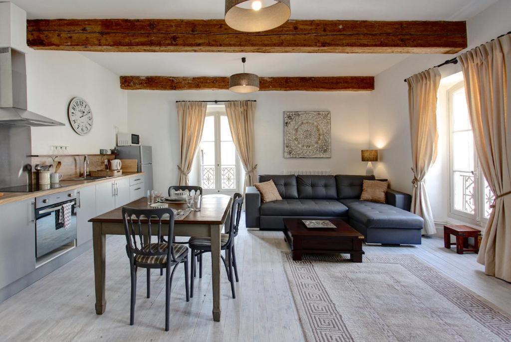 a living room with a table and a blue couch at Appartements du Vin in Caudiès-de-Fenouillèdes