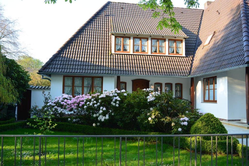 a white house with a fence in front of it at Apartment am Park in Bremerhaven