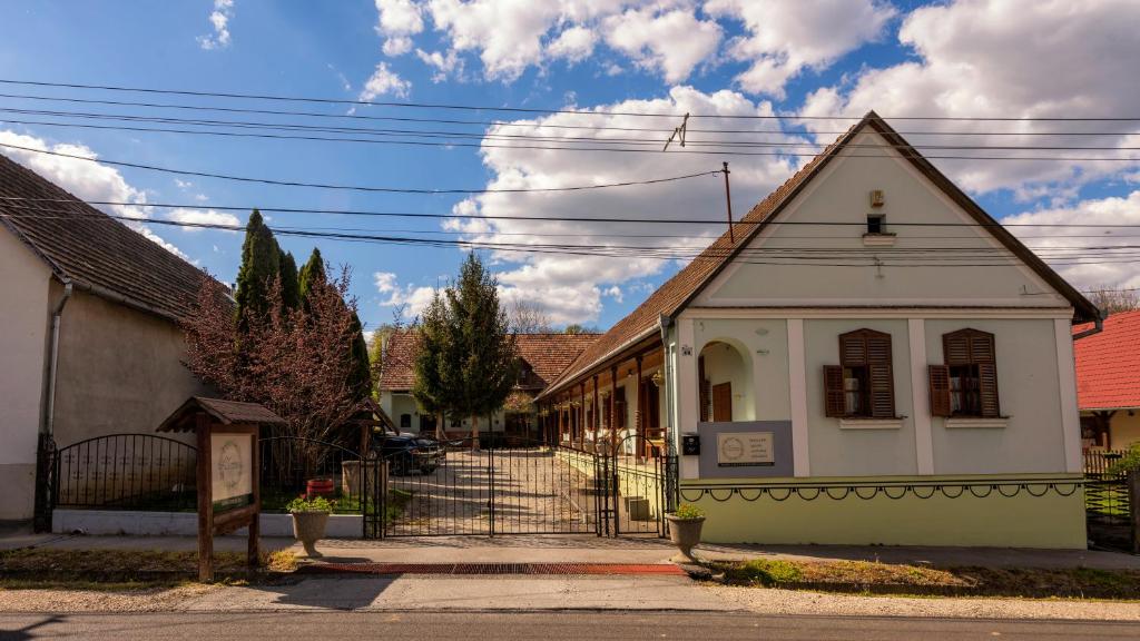 un pequeño edificio blanco al lado de una calle en Noresa Dekor és Panzió, en Szálka