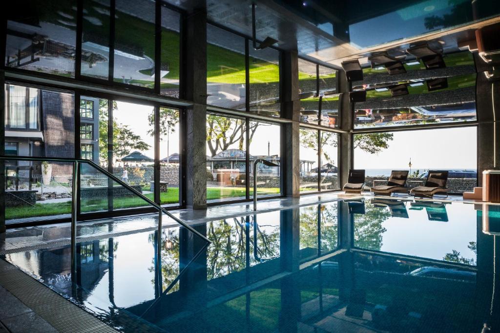 a swimming pool in a building with windows at Max Health Resort SPA in Ustronie Morskie