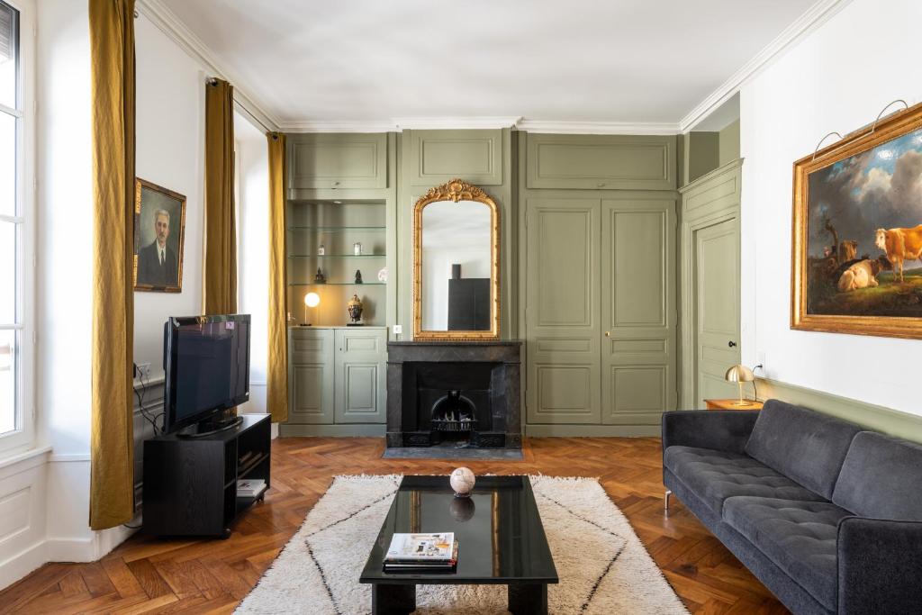 un salon avec un canapé et une cheminée dans l'établissement HONORÊ - Suite Victor Hugo, à Lyon