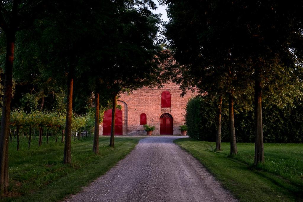 een onverharde weg die leidt naar een rode bakstenen kerk bij Alloggio Cantalupo in Formigine