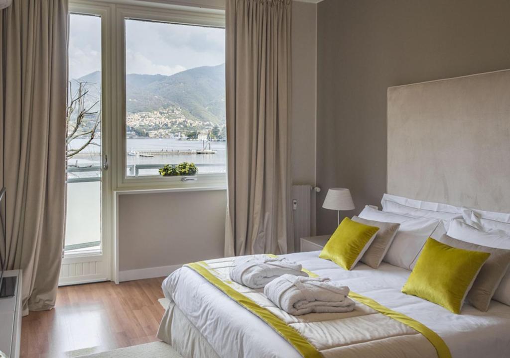 a bedroom with a bed with a large window at Como Lake Suites in Como