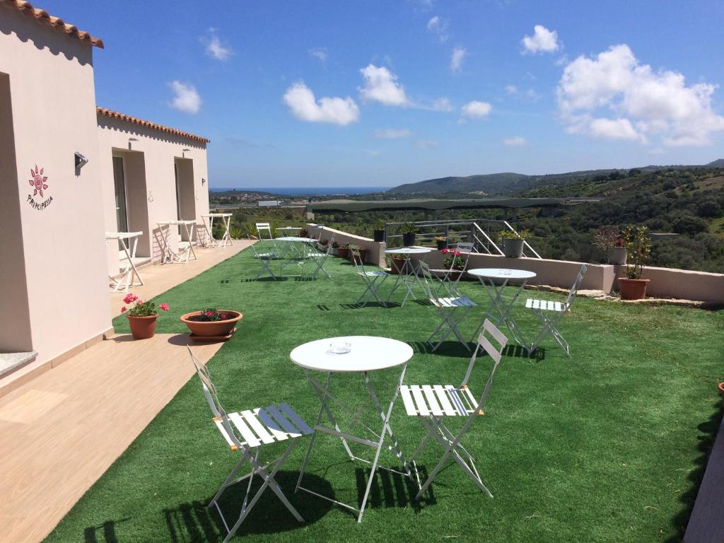 a patio with tables and chairs on the grass at Sole&Sale in San Teodoro