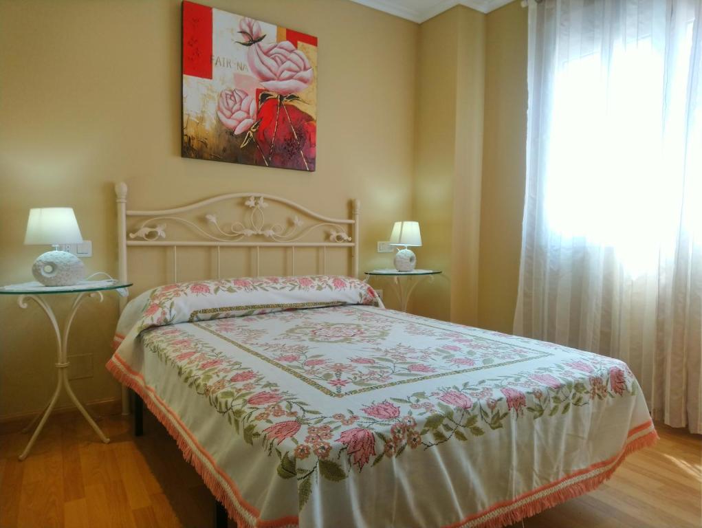 ein Schlafzimmer mit einem Bett und ein Fenster mit einem Gemälde in der Unterkunft La Casa Periquita in Rinlo