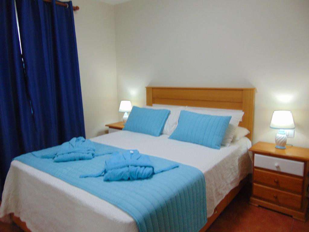 ein Schlafzimmer mit einem Bett mit blauen Kissen darauf in der Unterkunft Apatamento Aeropuerto 1 in Carrizal