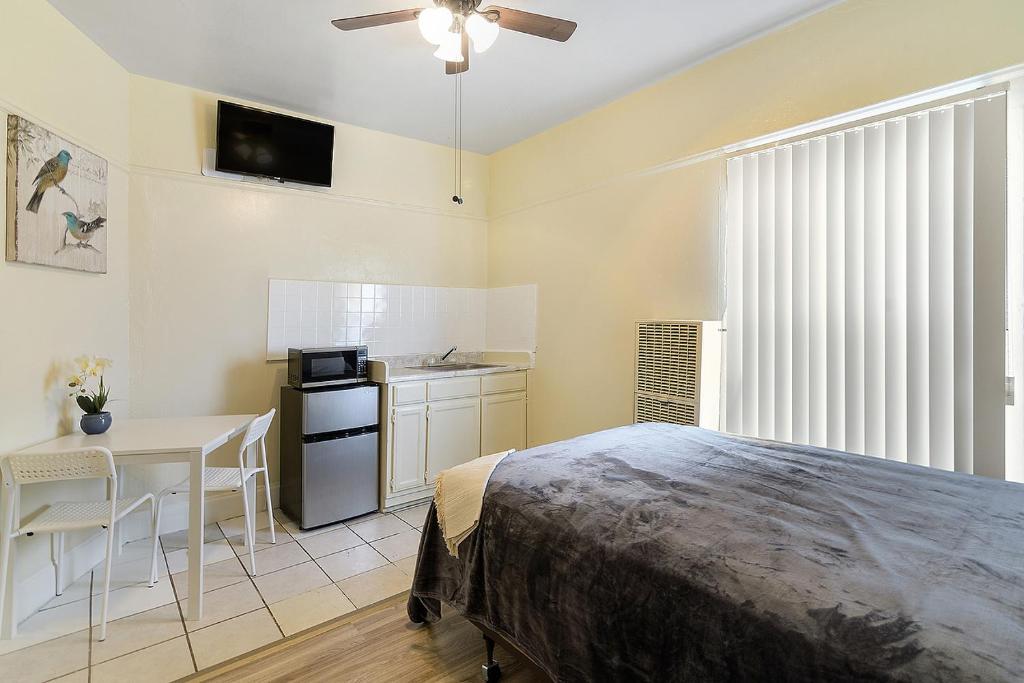 a bedroom with a bed and a table and a kitchen at Pads on Pasadena Ave in Los Angeles