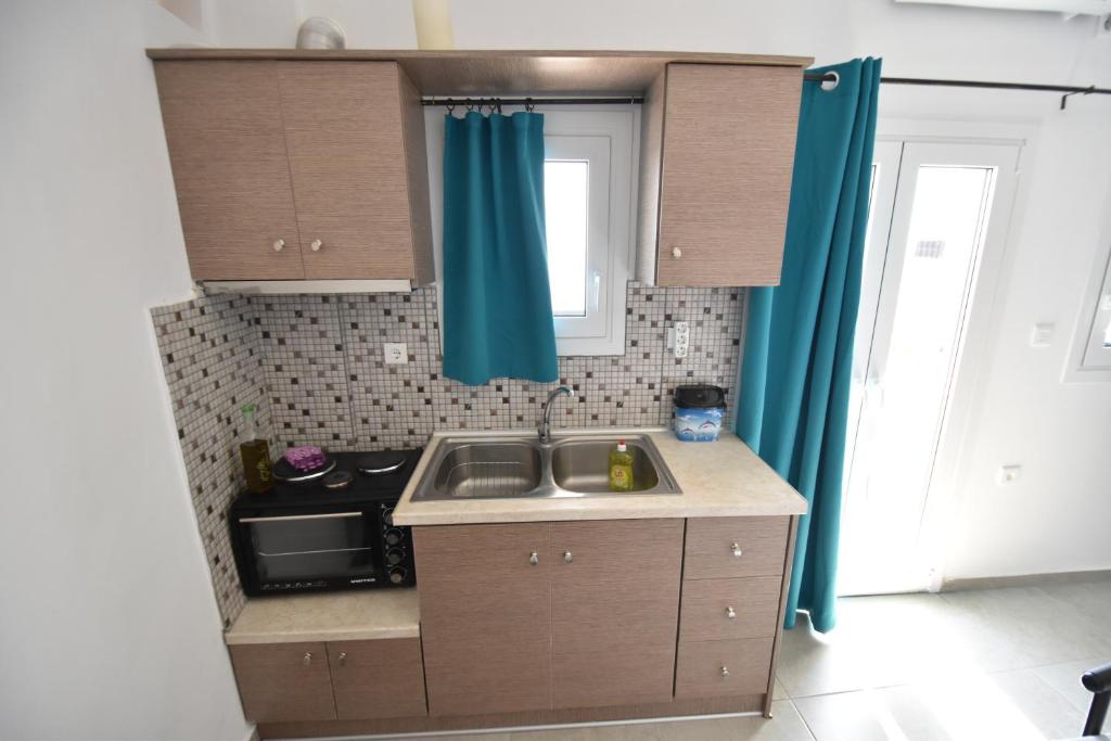 a small kitchen with a sink and a microwave at House With View in Paránimfoi