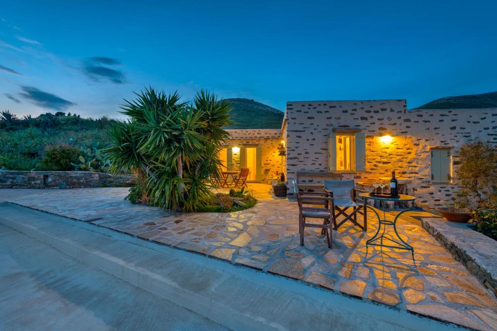 a patio with a table and chairs in front of a house at MEGAS GIALOS HARMONY in Megas Yialos-Nites