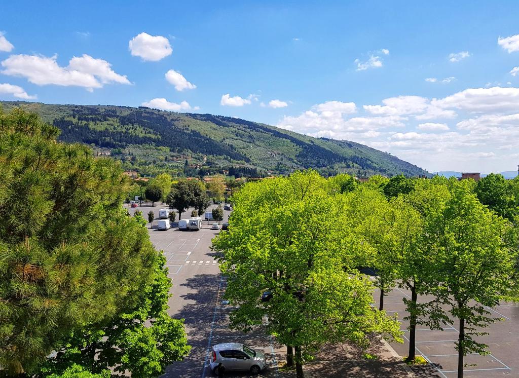 a parking lot with trees and a mountain in the background at Casa del Sole in Prato