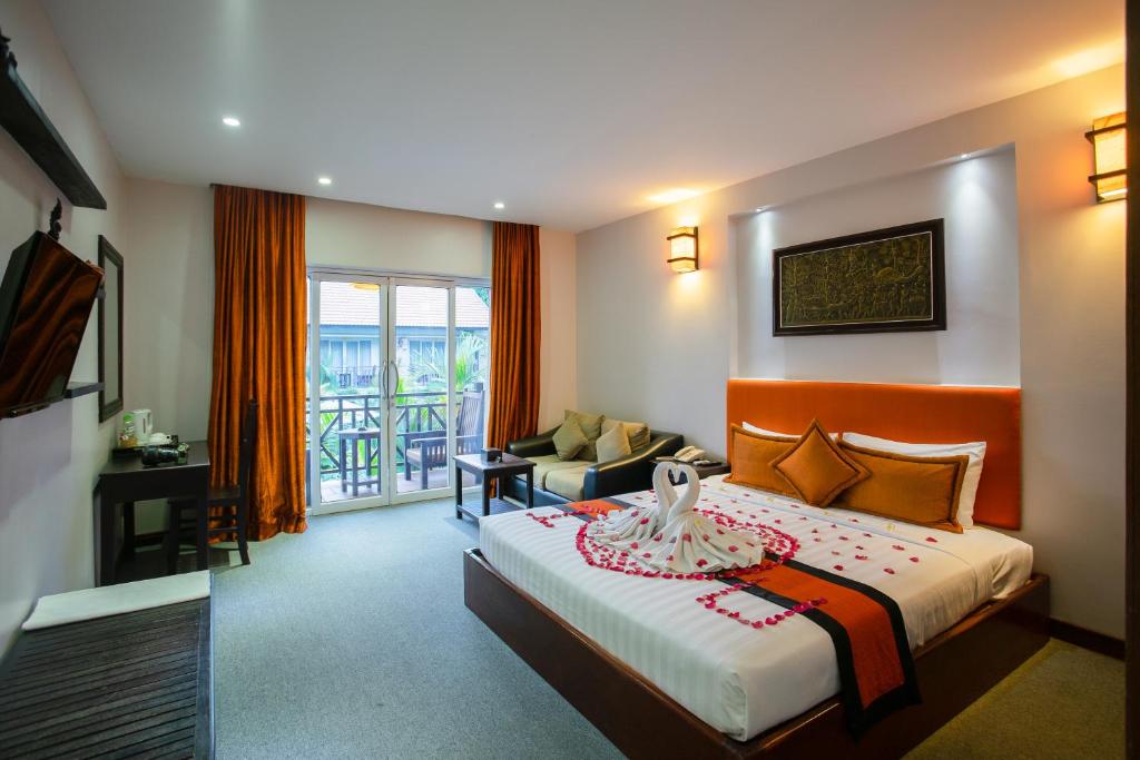 a hotel room with a bed and a balcony at Ra-Ta Boutique Hotel in Siem Reap