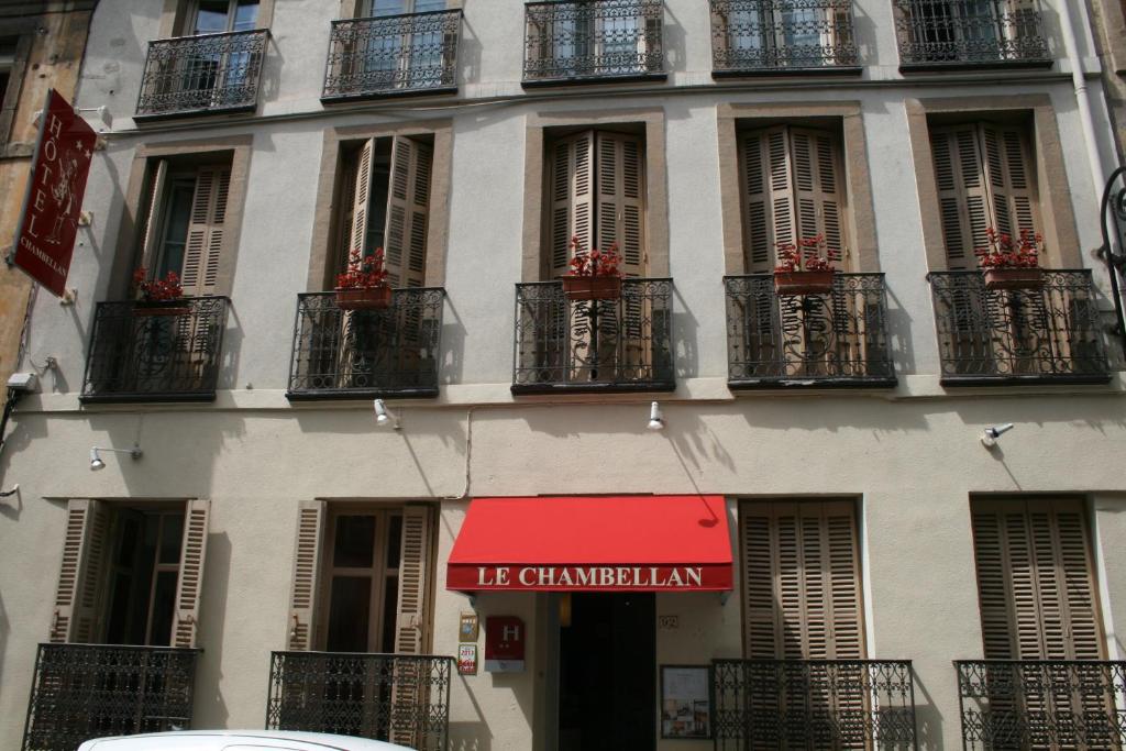 a building with balconies and a red sign on it at Hôtel Le Chambellan in Dijon