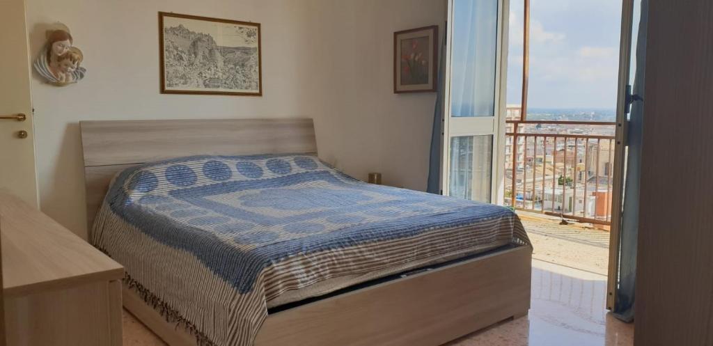a bedroom with a bed and a large window at Umberto 7 in Avola