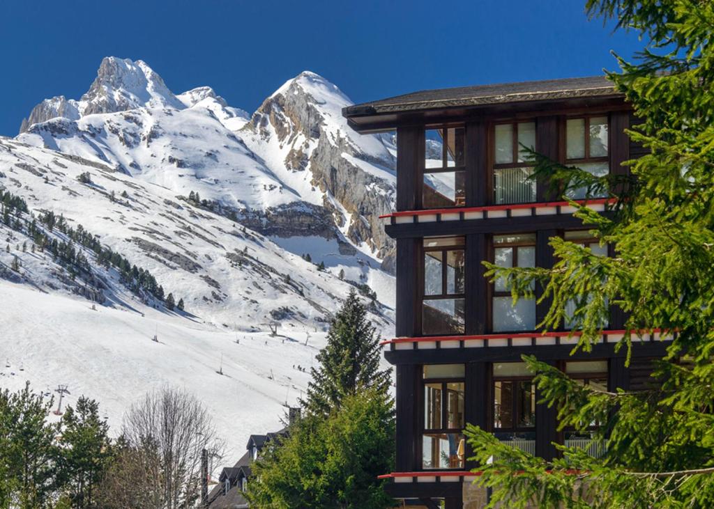 een gebouw met uitzicht op een met sneeuw bedekte berg bij Hotel Candanchú in Candanchú