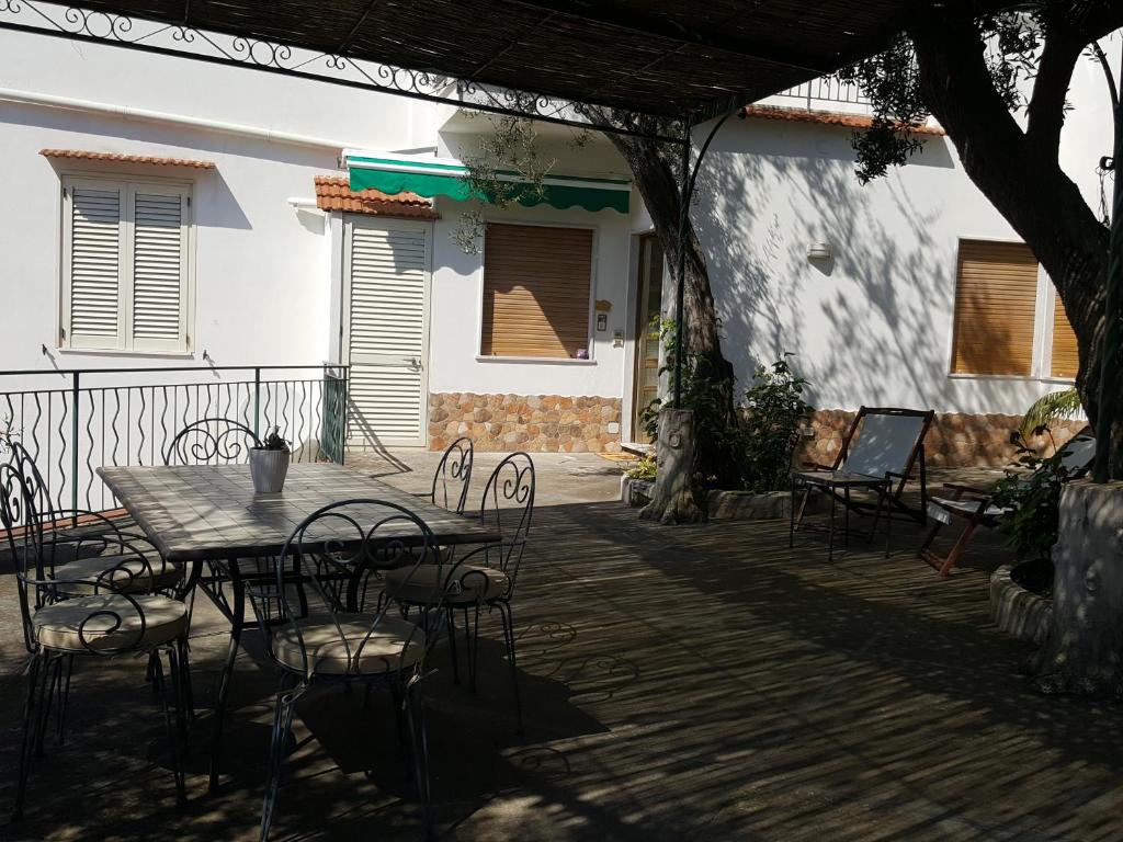 un patio con mesa y sillas en una terraza en La Scaletta Casa Vacanze en Massa Lubrense
