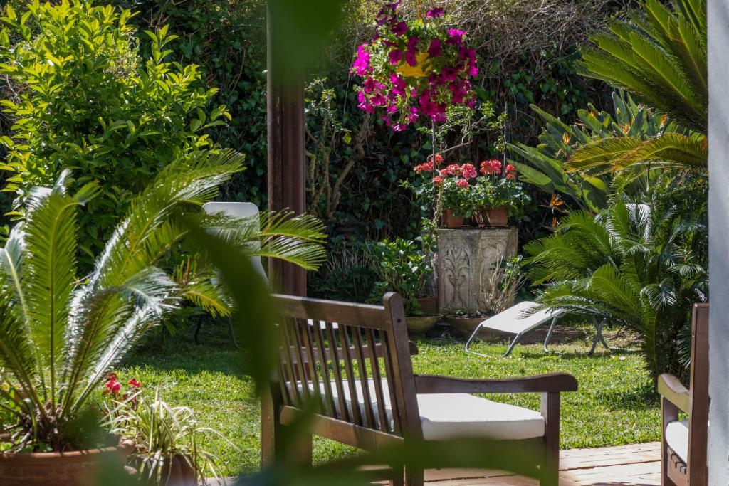 ławkę w ogrodzie z kwiatami i roślinami w obiekcie Villa Gabriella - Mondello w mieście Mondello