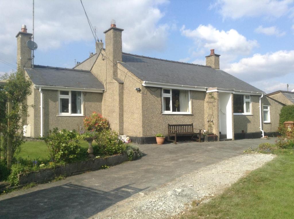 a house with a bench in front of it at tabor lane Dolwar our little cottage in Criccieth