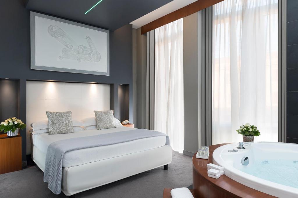 una camera con letto e vasca da bagno di Metropolis - Hotel di Charme a Roma