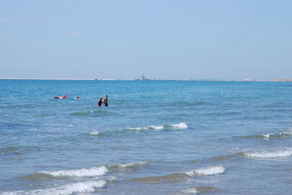 a group of people swimming in the ocean at Hotel Valdor in Cavallino-Treporti