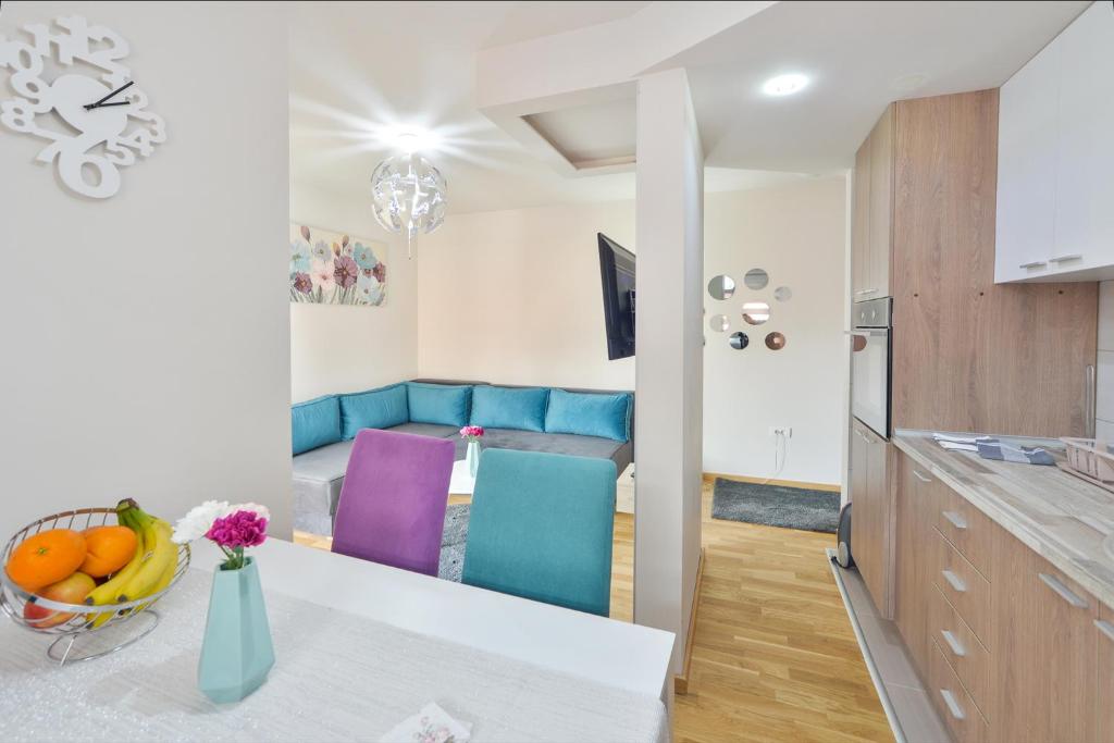 Il comprend une cuisine et un salon doté d'un canapé bleu. dans l'établissement Apartman Alex Zlatibor, à Zlatibor