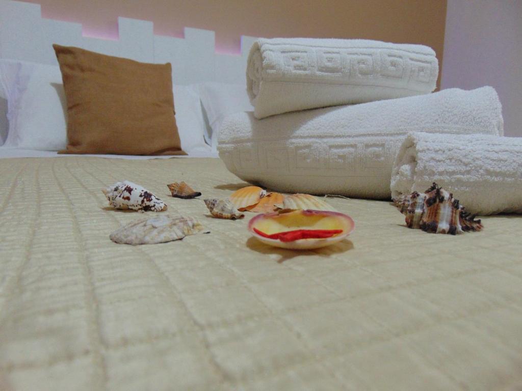 a white bed with some food on it at Case Vacanza Donatella in San Vito lo Capo