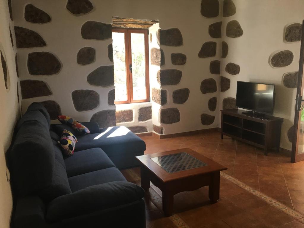 聖巴托洛梅的住宿－COUNTRY HOUSE MIS ABUELOS TAIDIA，客厅配有蓝色的沙发和桌子