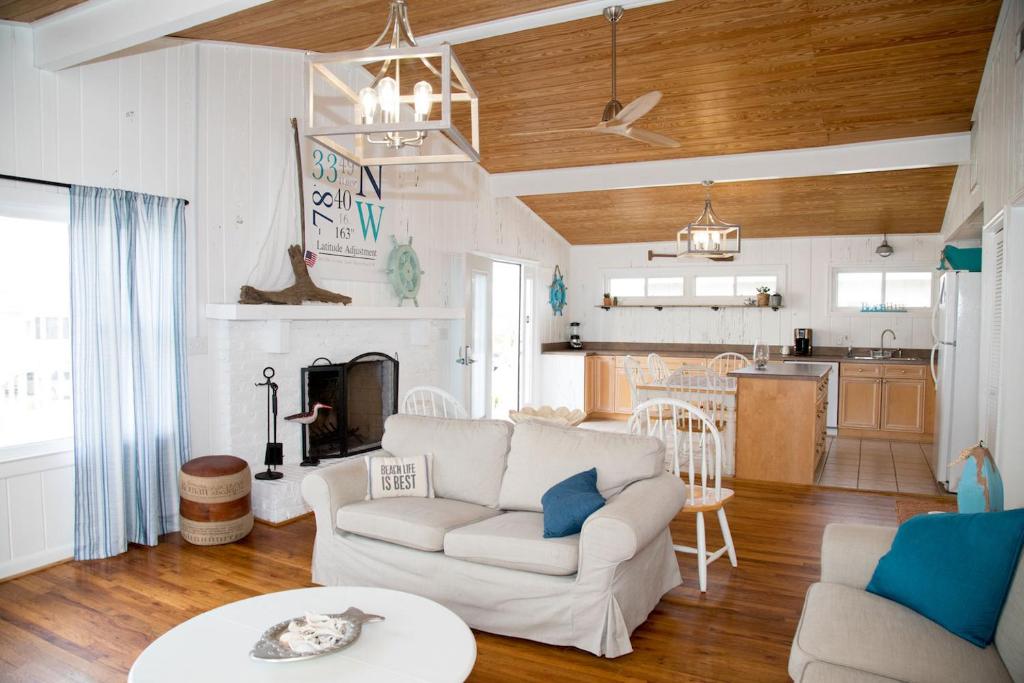 a living room with a white couch and a kitchen at Latitude Adjustment in Myrtle Beach