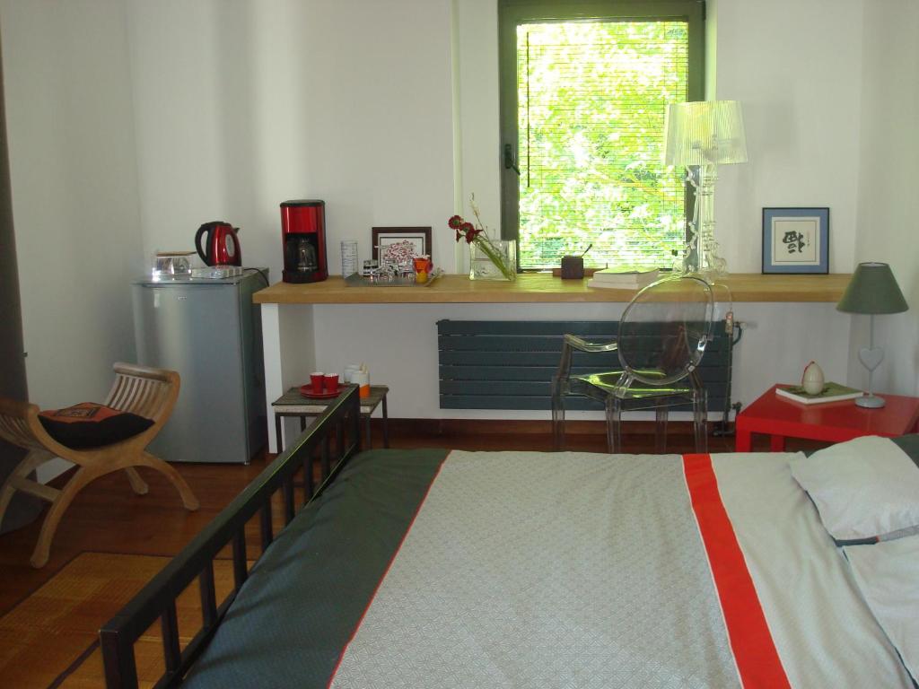 a bedroom with a bed and a desk and a window at La Chambre du Meunier in Laiz