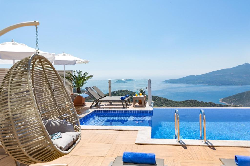 a swing by a pool with a view of the ocean at Villa La Mer Azur in Kalkan