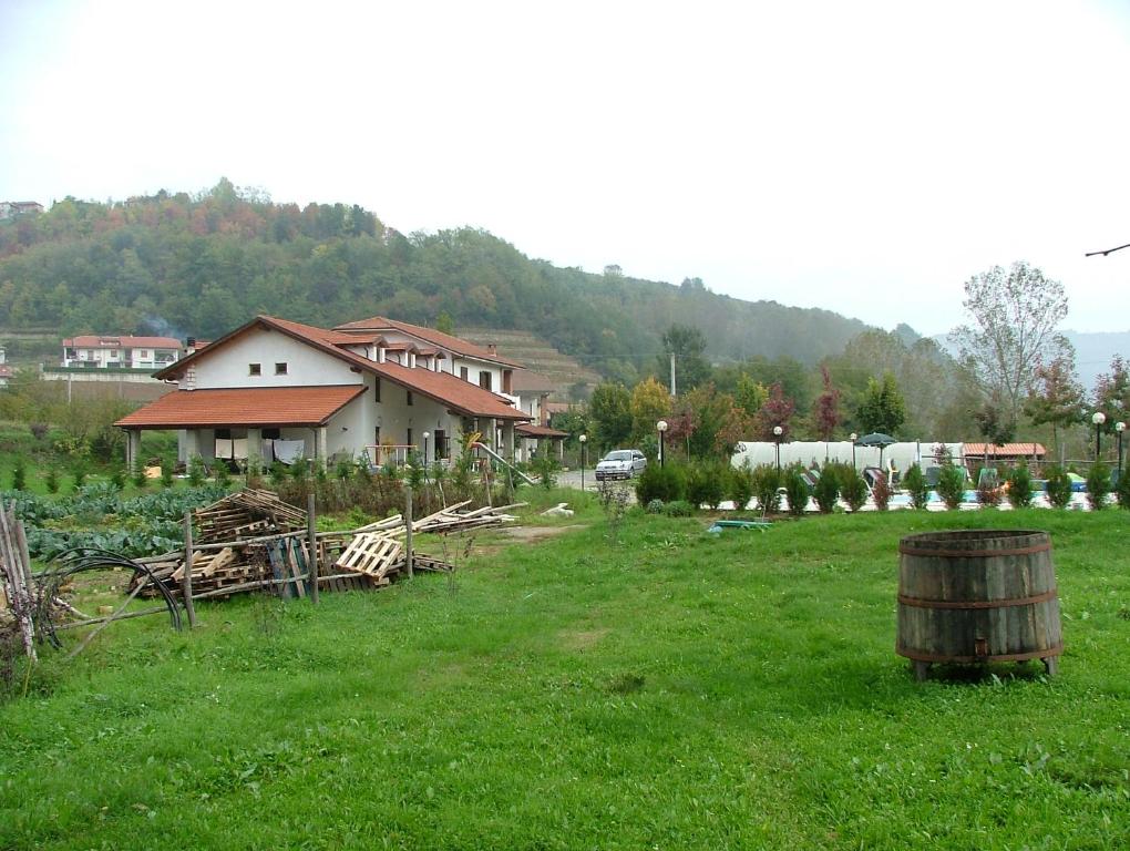 una casa en un campo con un barril en la hierba en Agri BERTORELLA, en Cuneo