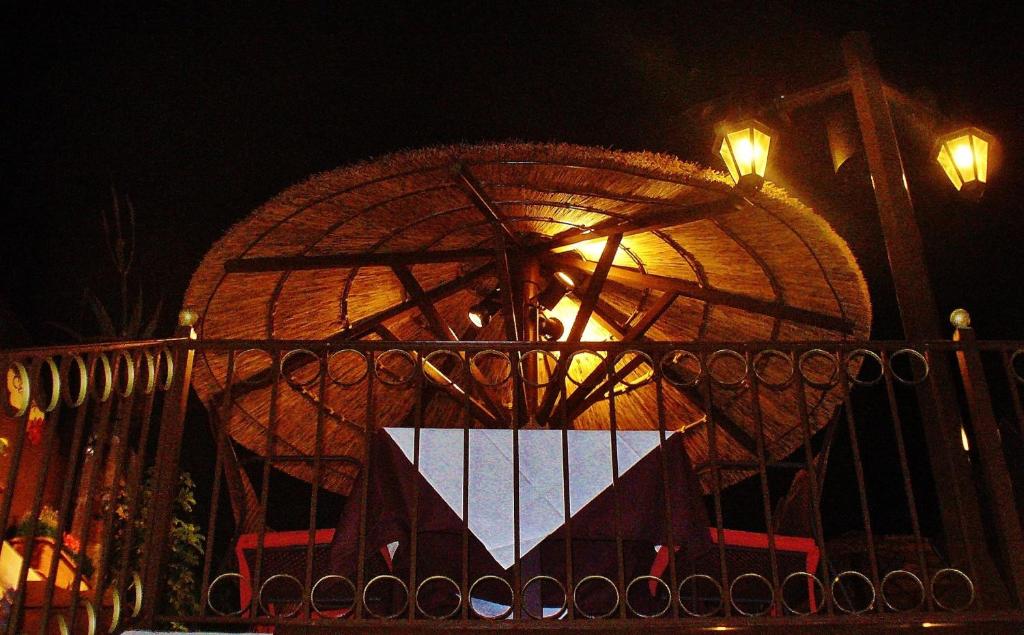 an umbrella behind a fence at night at 24 Seven Boutique Hotel in Malia