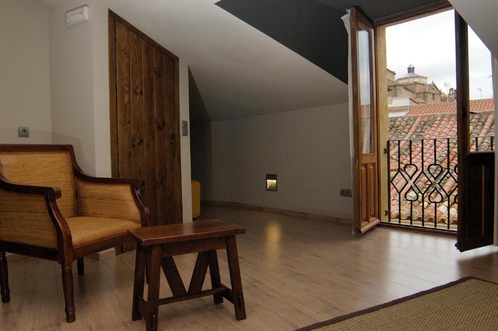 a living room with a chair and a balcony at Casa Rural La Botica in Oropesa