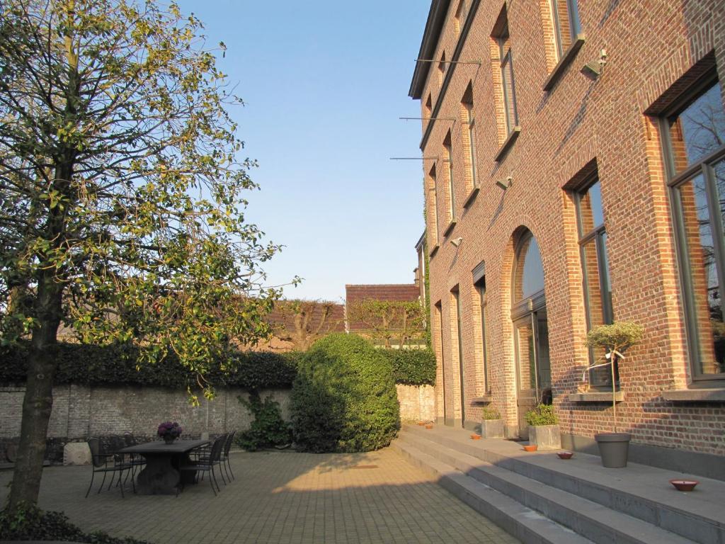 a courtyard with a table and chairs next to a building at B&B La Corderie in Hamme